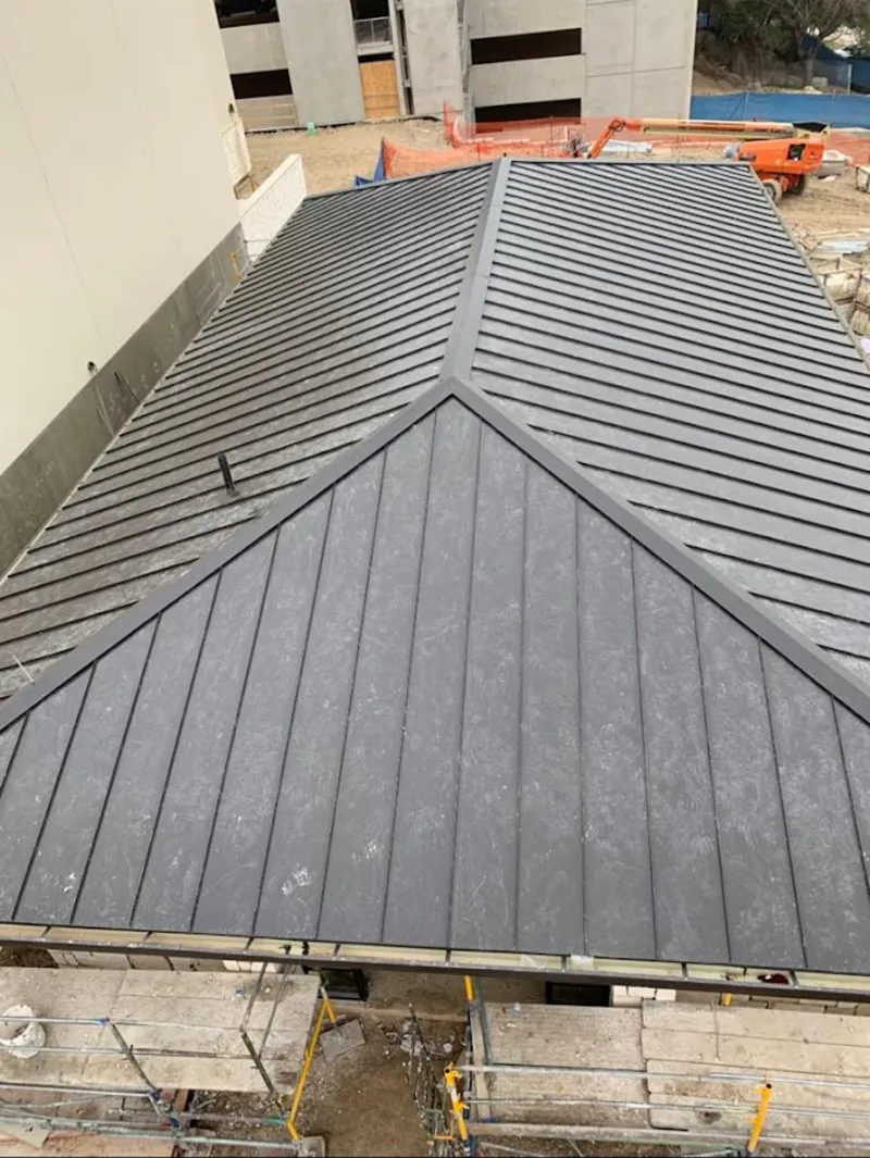 Commercial metal roof construction with crane equipment in Belmar